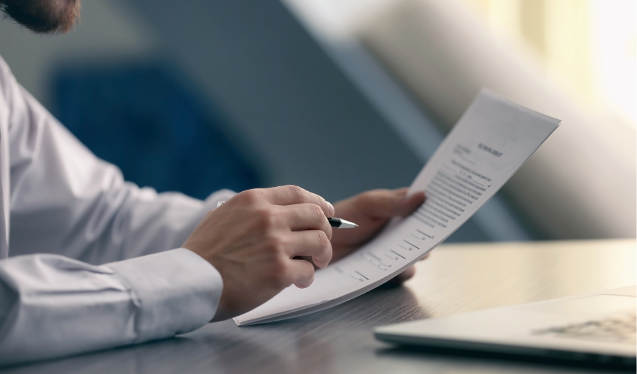 Homme consultant un document juridique sur une charte de confidentialité à son bureau, illustrant les obligations légales de protection des données personnelles.