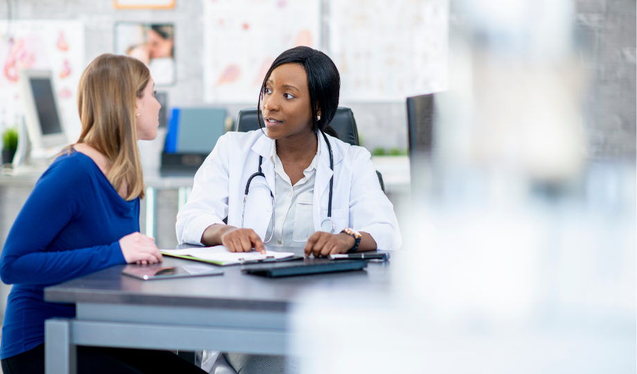 Une infirmière informe une patiente sur le déroulement des essais cliniques dans un établissement de santé.