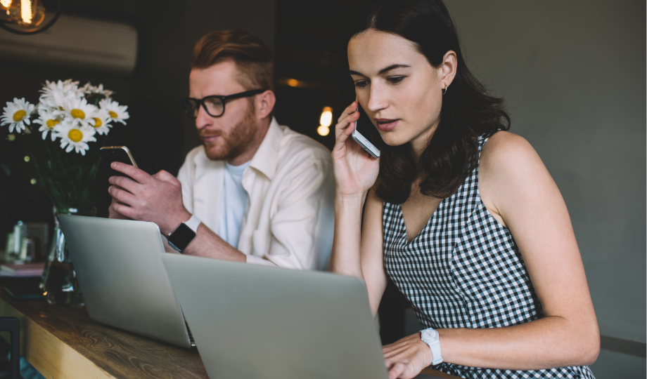 Deux professionnels travaillent sur ordinateur et téléphone pour illustrer la prospection commerciale B2B fondée sur les intérêts légitimes.