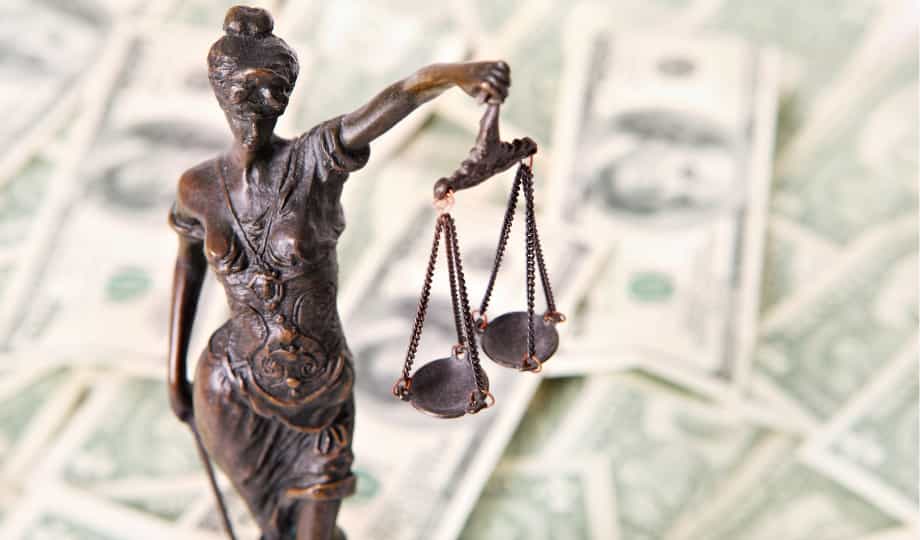 Statue de la justice tenant une balance devant des billets de dollar, symbolisant la lutte contre la corruption — Loi Sapin 2