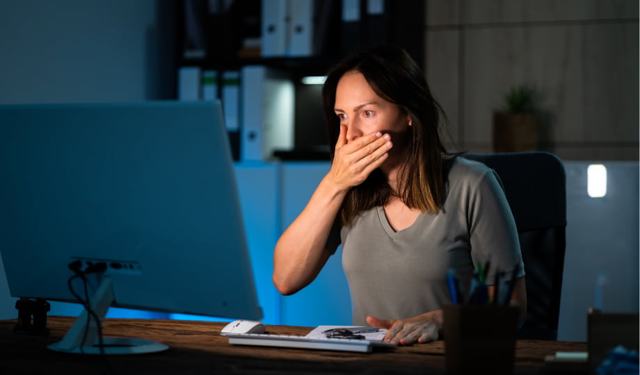 Woman shocked in front of her screen, illustrating the operational risks and incidents that Dora aims to prevent in systems using AI.