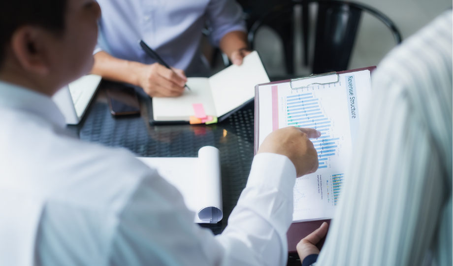 Réunion d’équipe examinant des graphiques, représentant la gouvernance et le cadre de conformité exigés par Dora.ia pour maîtriser les risques technologiques.
